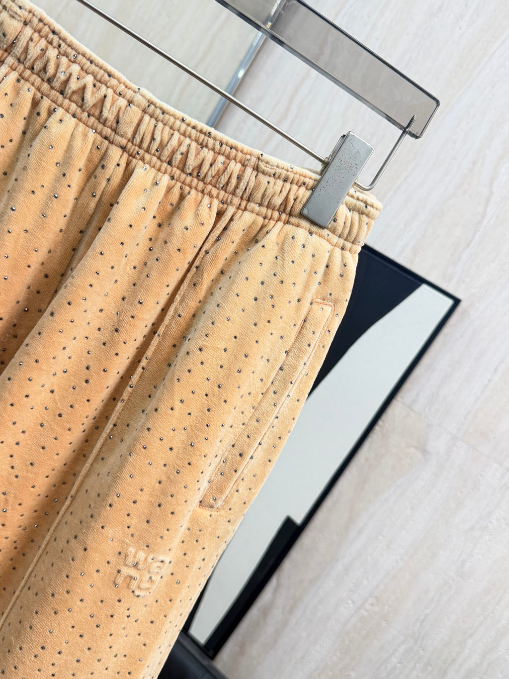 Beige dotted wide-leg pants with elastic waistband and visible front pleats