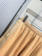Beige allover tiny dot pants with elastic waistband and draped wide legs