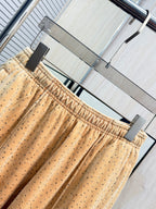 Beige dot-print pants with elastic waist and tapered gathered cuffs at bottom