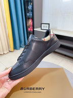 Dark blue leather low-top sneaker held by hand with striped knit collar trim