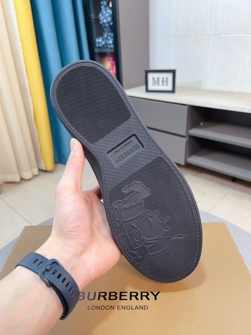 Rubber outsole of dark leather sneaker with embossed logo and textured traction pattern