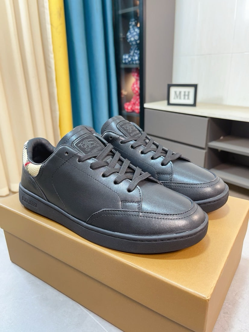 Pair of dark blue leather low-top sneakers with lace-up design and padded ankle collar