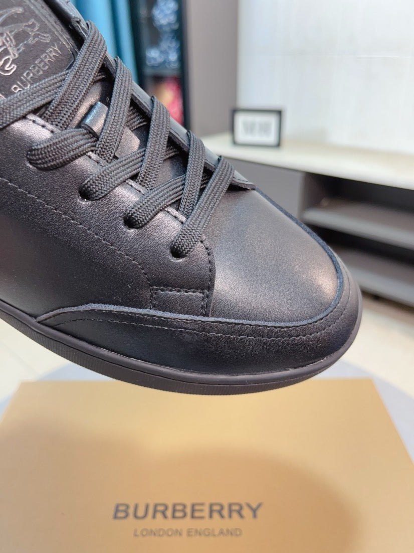 Front view of dark leather low-top sneaker with lace eyelets and stitched panels