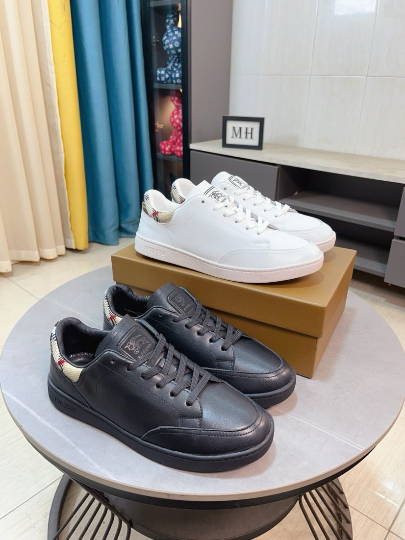 Leather low-top sneakers in white and dark color with lace-up fronts and rubber soles