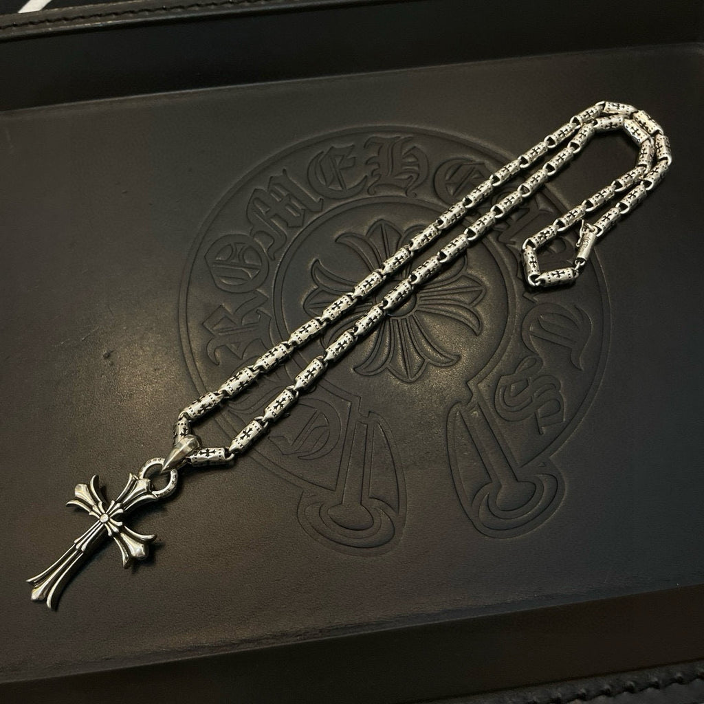 Silver-tone textured chain necklace with cross pendant and lobster clasp ends.