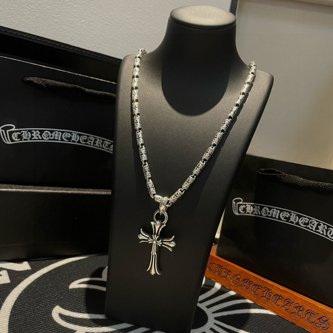 Silver-tone cross pendant necklace with textured link chain and hanging cross charm.