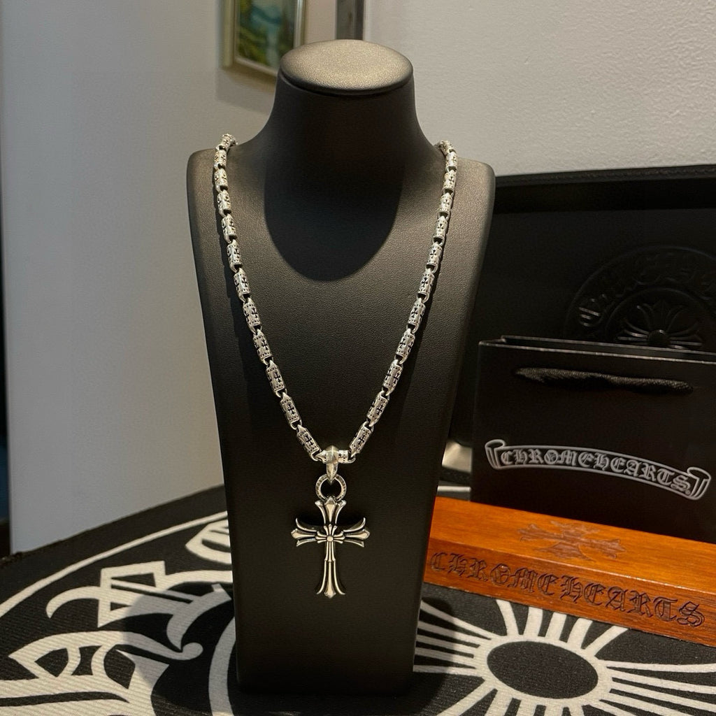 Silver-tone cross pendant necklace with textured link chain and small clasp detail.