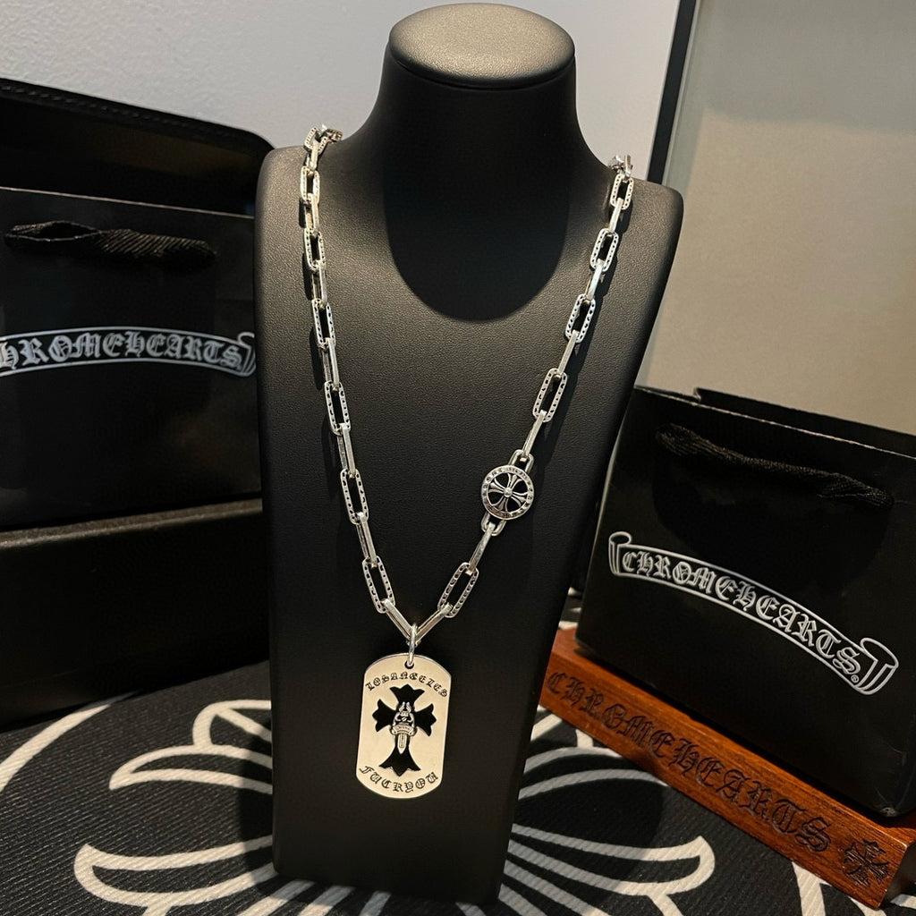 Silver chain necklace on black bust display with circular and round charms