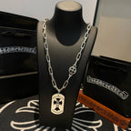 Silver chain necklace on black bust display with circular and round charms