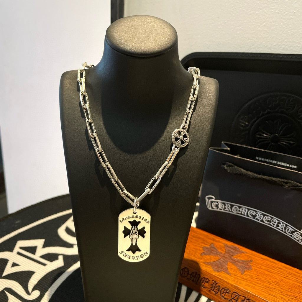 Silver chain necklace with circular pendant featuring cross-style symbol