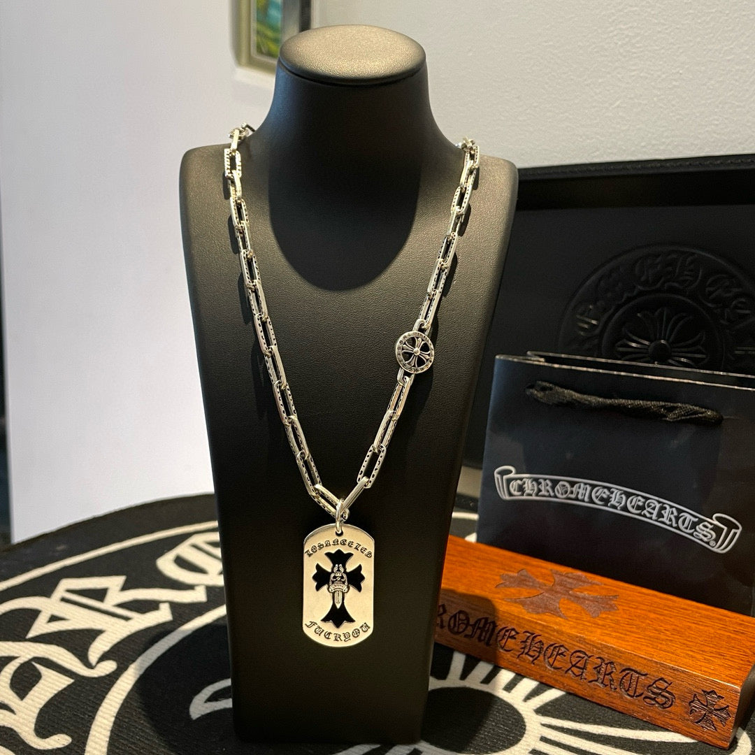 Silver chain necklace with circular charm pendant and cross-style center charm