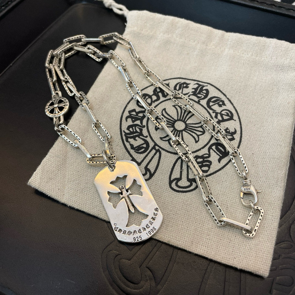 Silver chain necklace with gold-tone dog tag and circular charm on pouch