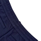 Close-up of navy pant side panel with stitched seam and pocket edge
