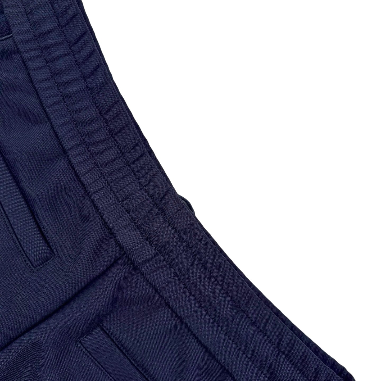 Close-up of navy pant side panel with stitched seam and pocket edge