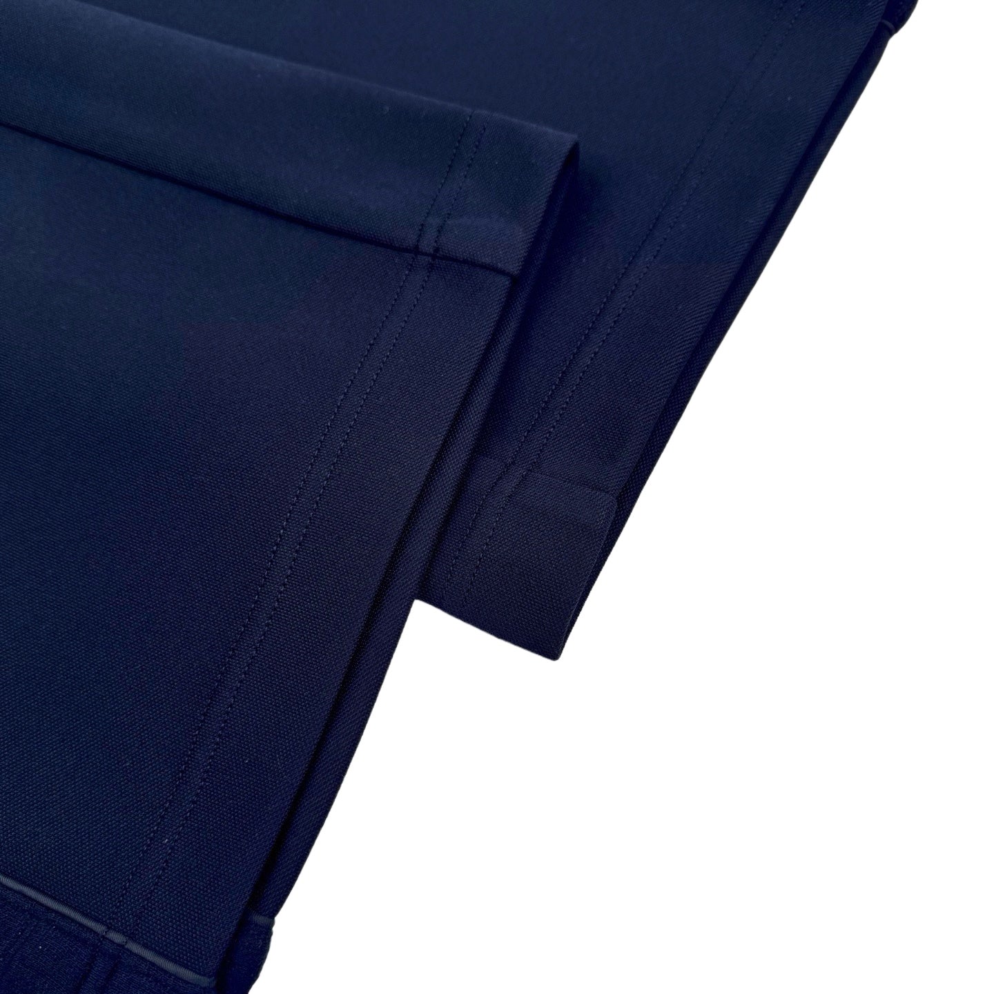 Close-up of navy pants hem with stitched panel and seam finish