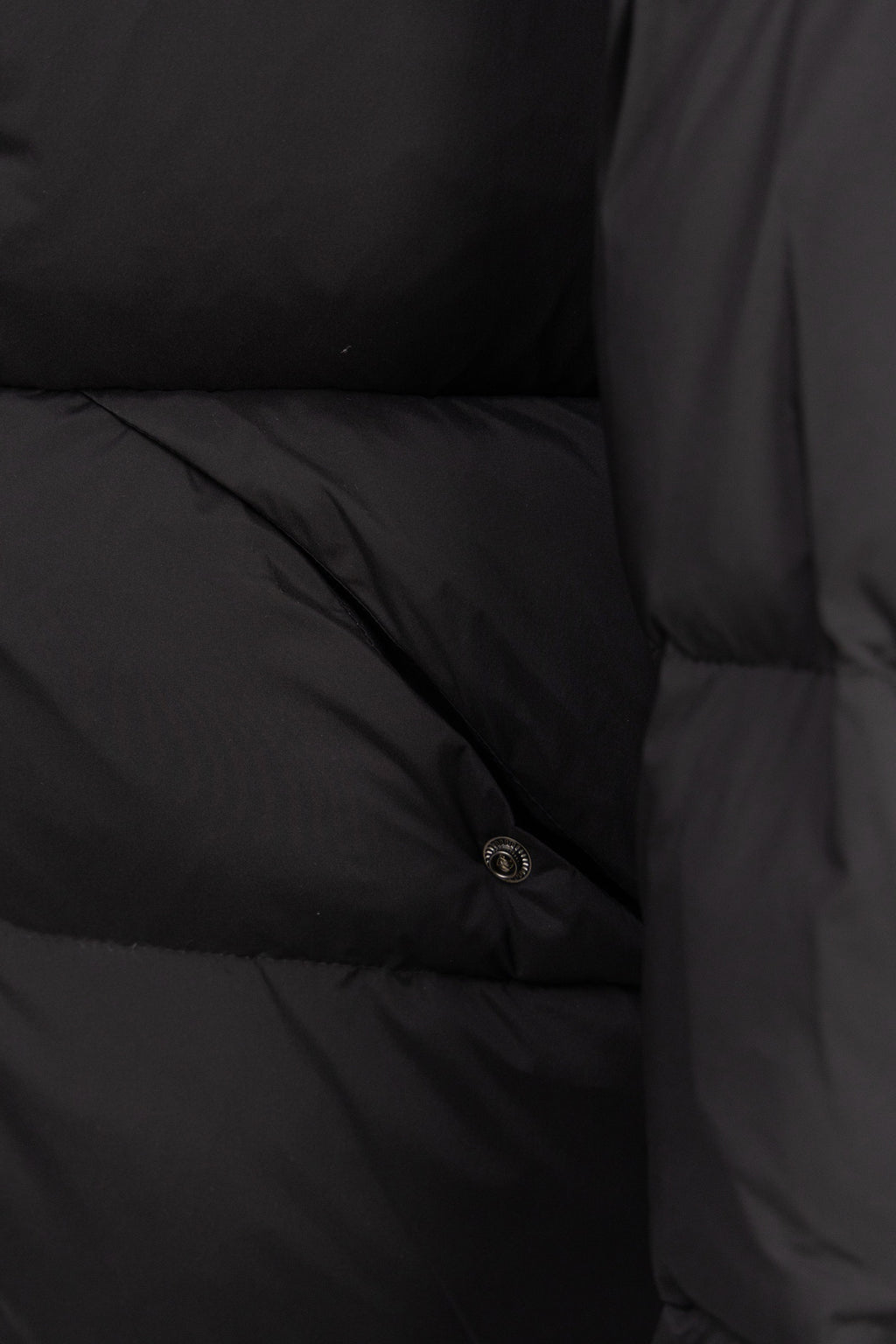 Dark puffer coat lining with stitched quilted sections and small snap button
