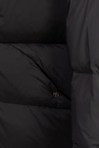 Dark puffer coat lining with stitched quilted sections and small snap button