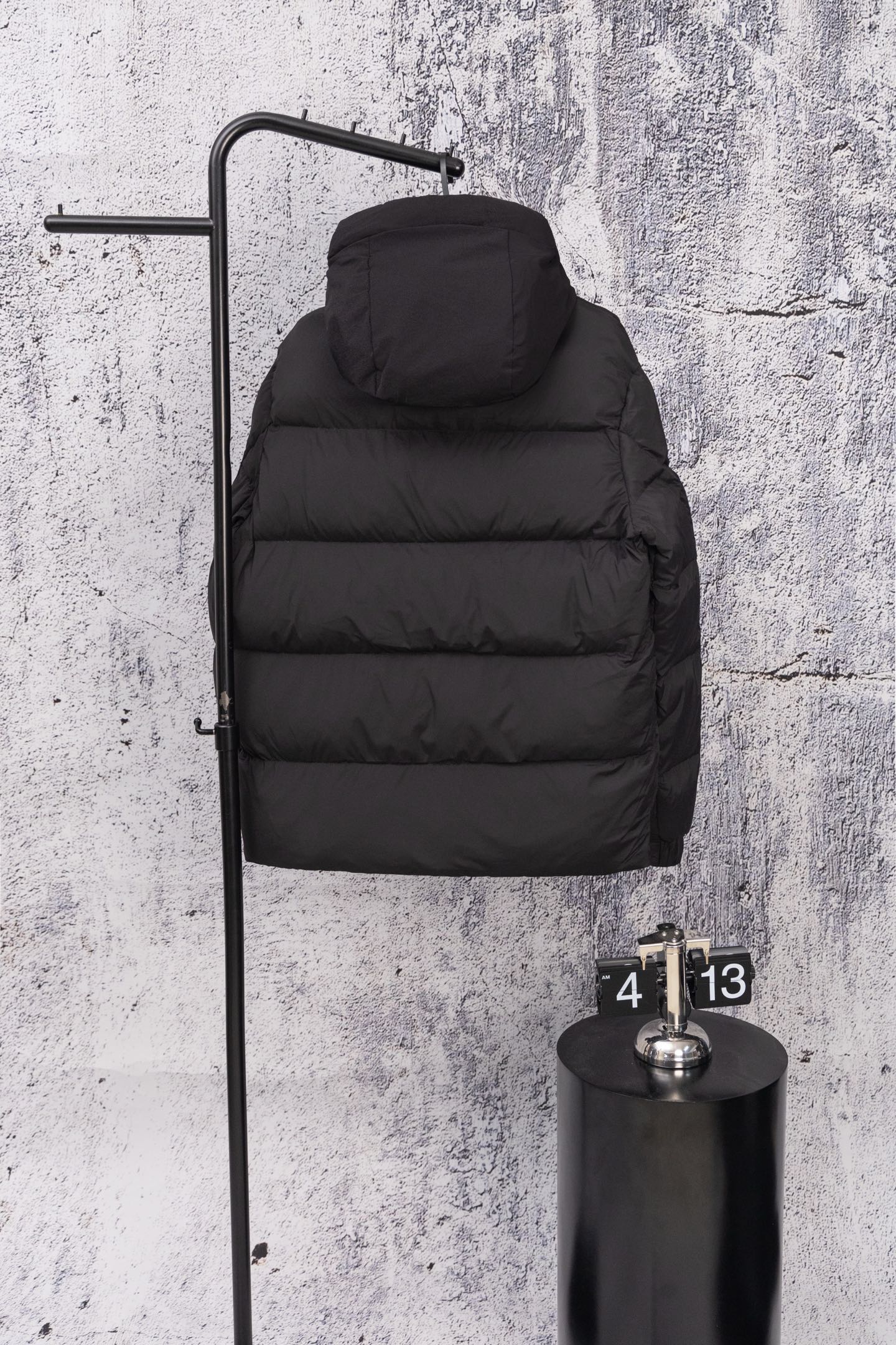 Moncler long hooded puffer jacket, dark, hood up on wall display