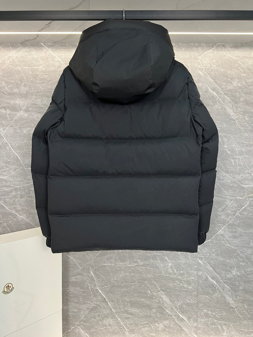 Moncler long hooded puffer jacket, black, close-up back view with hood