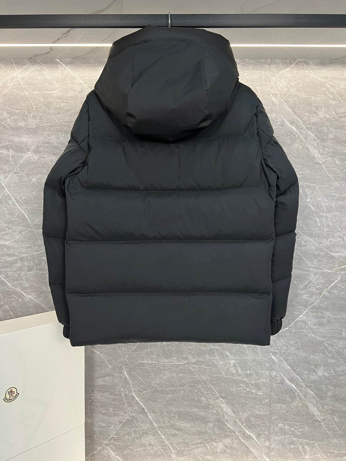Moncler long hooded puffer jacket, black, close-up back view with hood