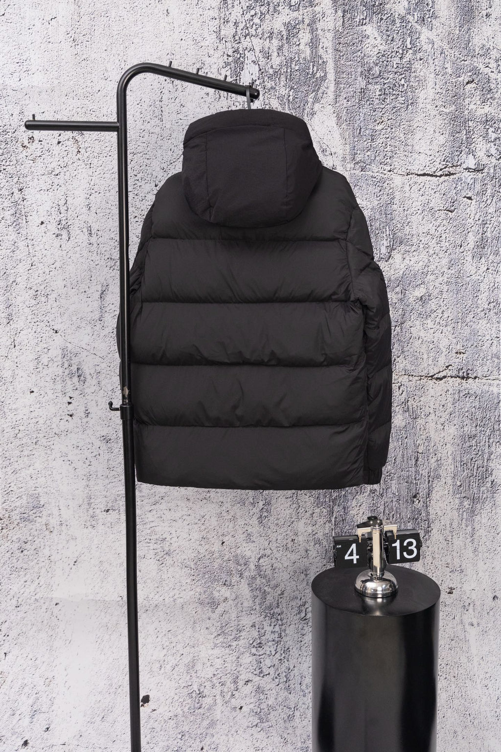 Moncler long hooded puffer jacket, dark, hood up on wall display