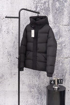 Moncler long hooded puffer jacket, dark, front view on wall display with zip