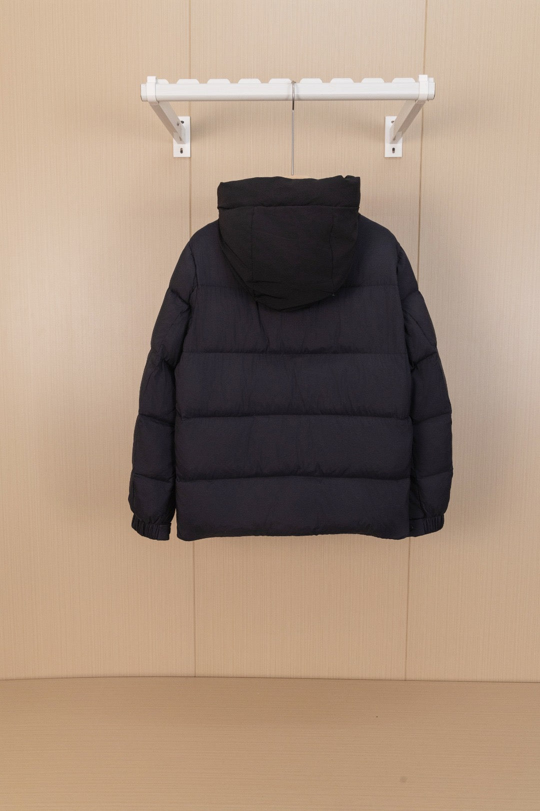 Moncler long hooded puffer jacket, black, back view on hanger