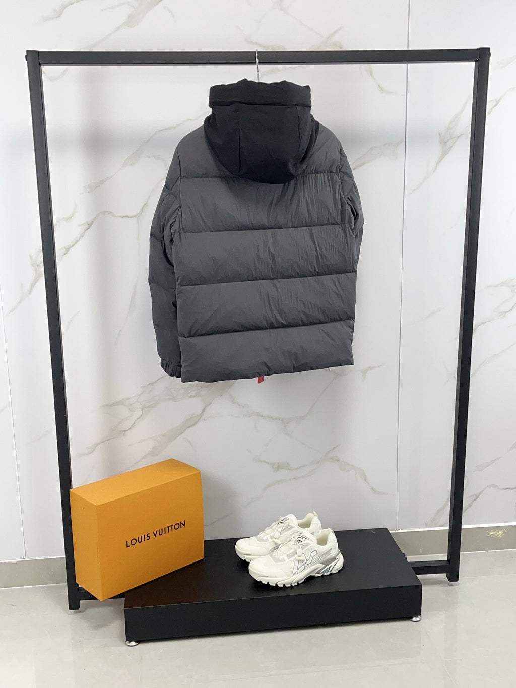 Long hooded puffer jacket, back view, dark gray quilted insulation