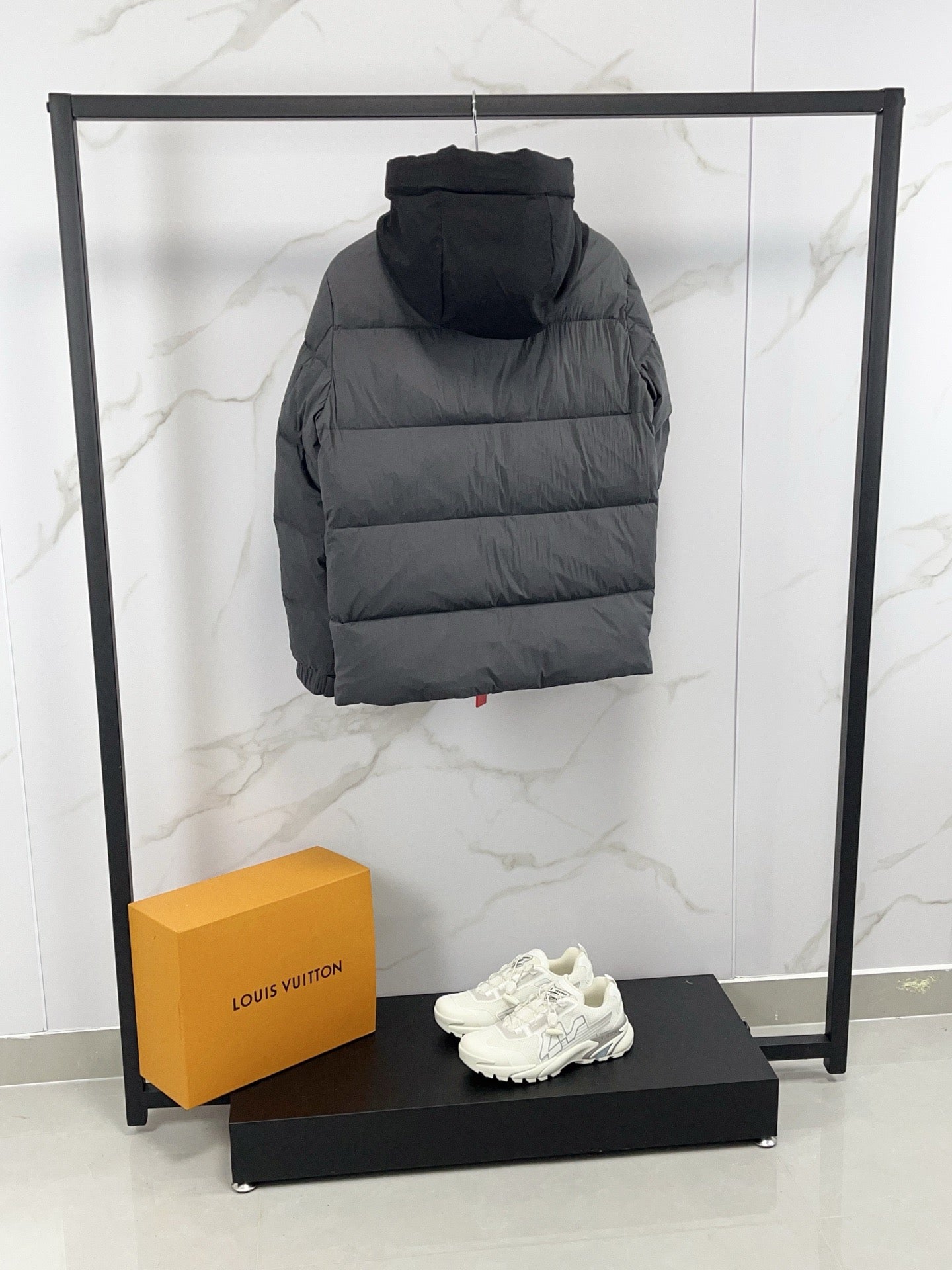 Long hooded puffer jacket, back view, dark gray quilted insulation