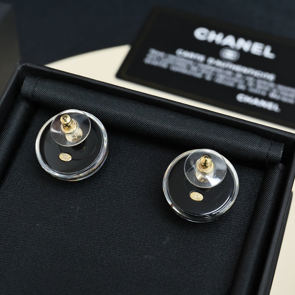 Round stud earrings in clear circular backings with gold posts