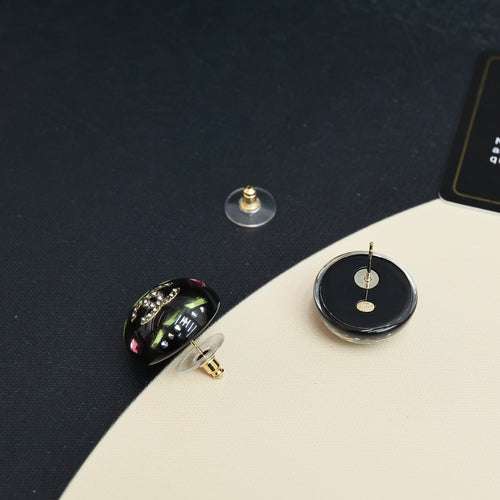 Round stud earrings with black disc backs and gold posts