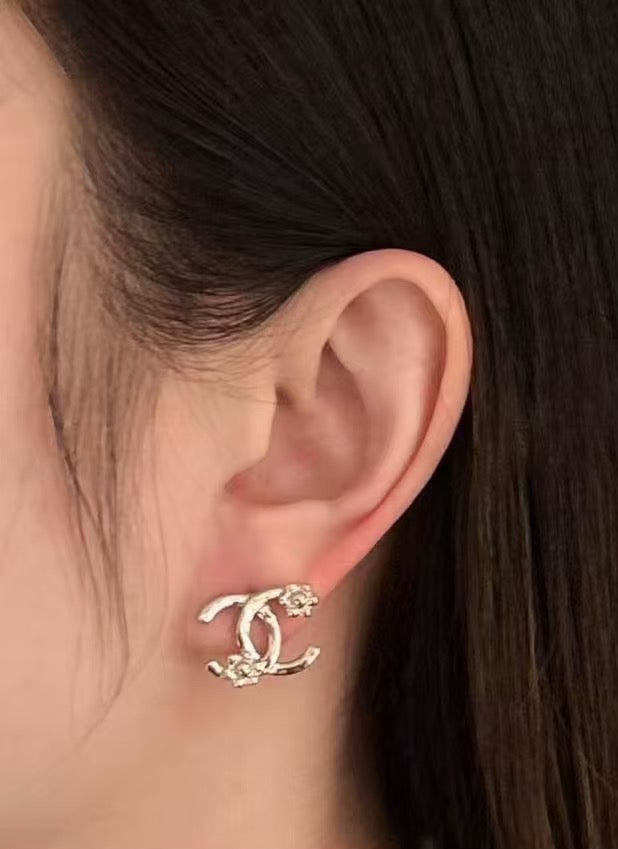 Chanel hoop earrings with gold-tone and crystal details, worn on ear