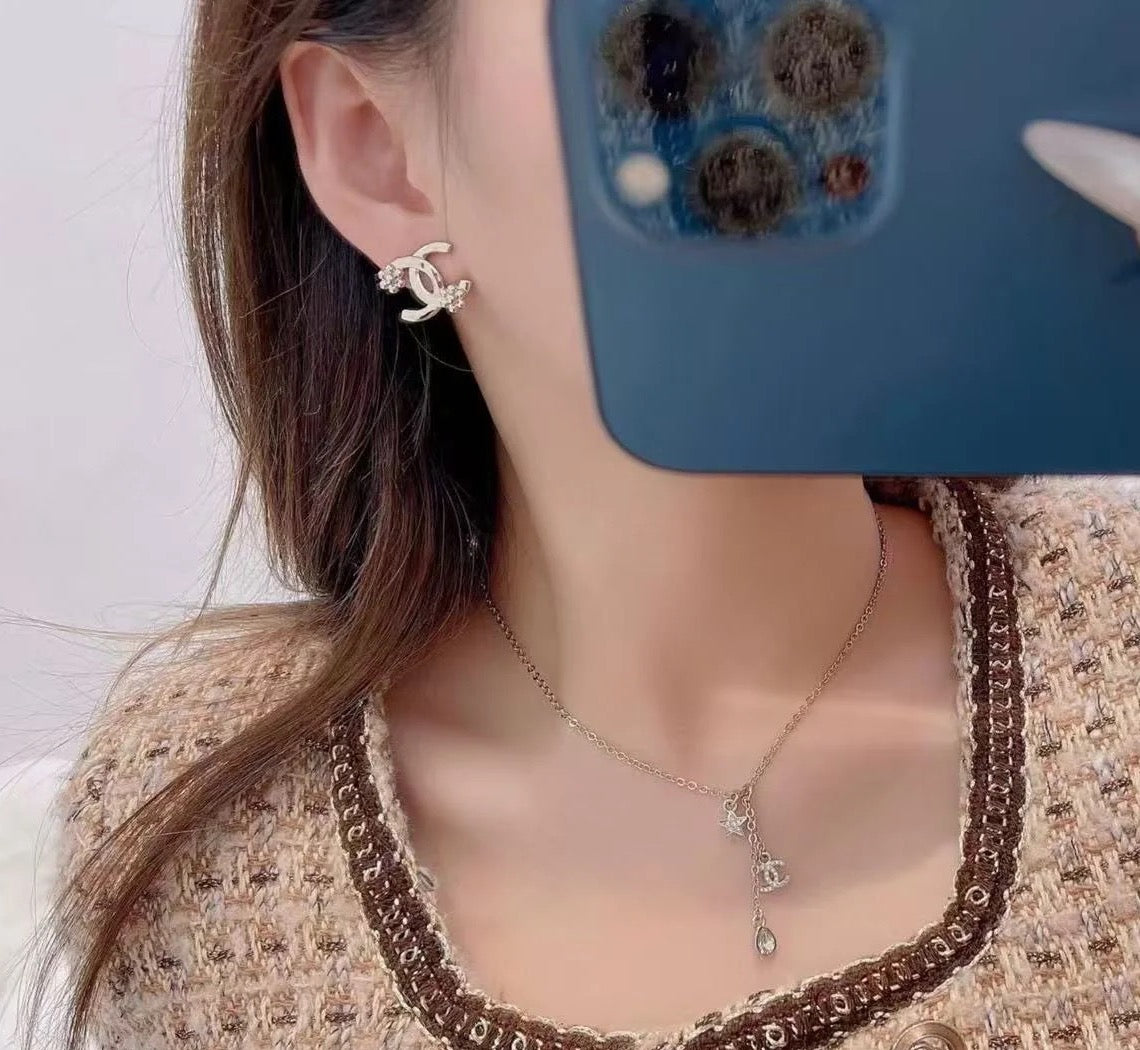 Chanel hoop earrings with gold-tone and crystal details, worn with pendant necklace