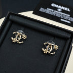 Chanel hoop earrings with gold-tone chain and dark stones, laid in black box