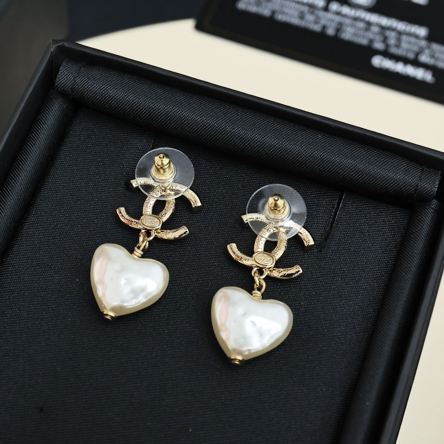 Gold-tone heart drop earrings with pearl-like white heart charms