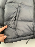 Gray puffer jacket front panel with quilt stitching, center seam, and zipper