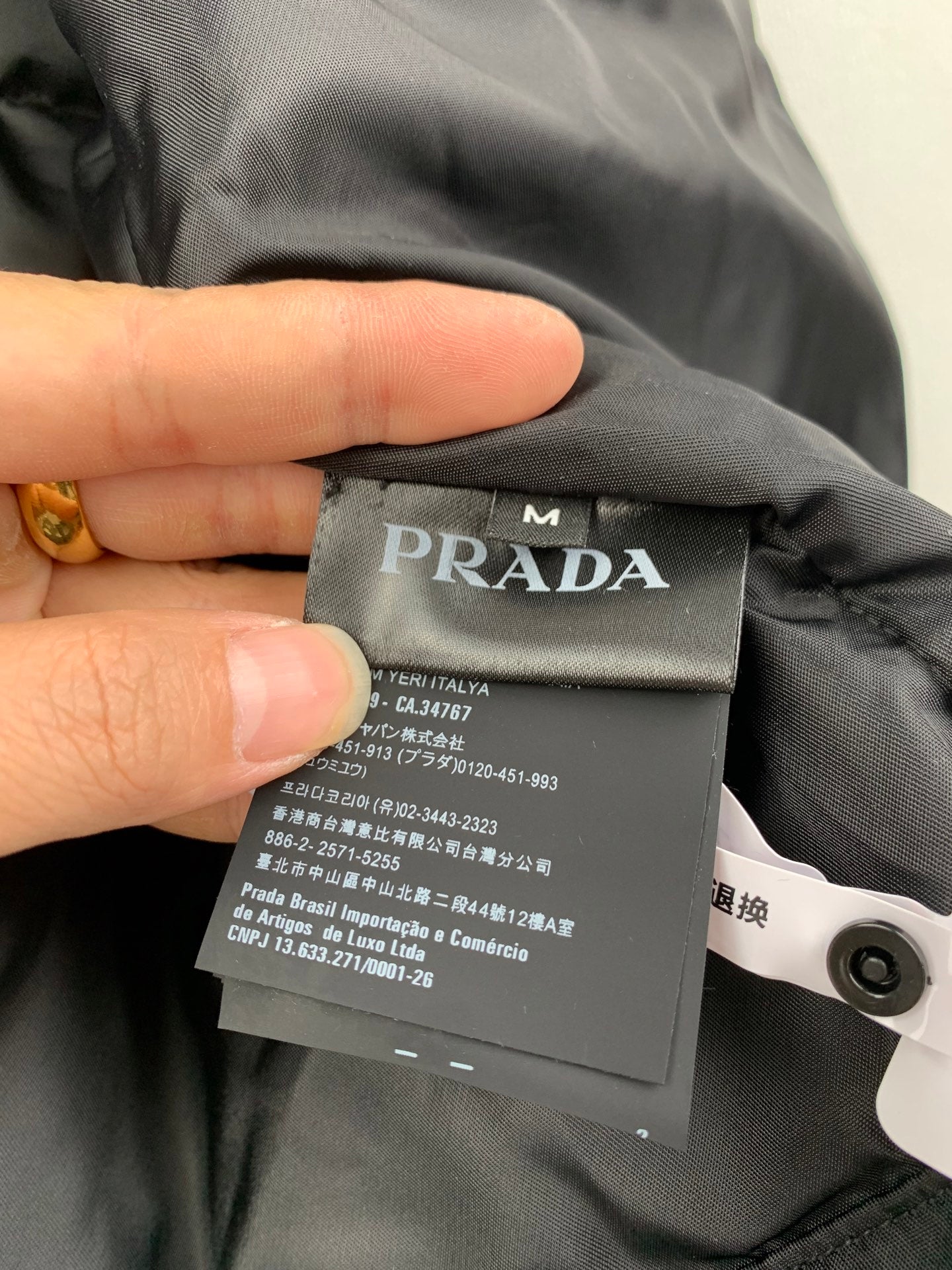 Long garment with Prada interior size and care label on dark fabric