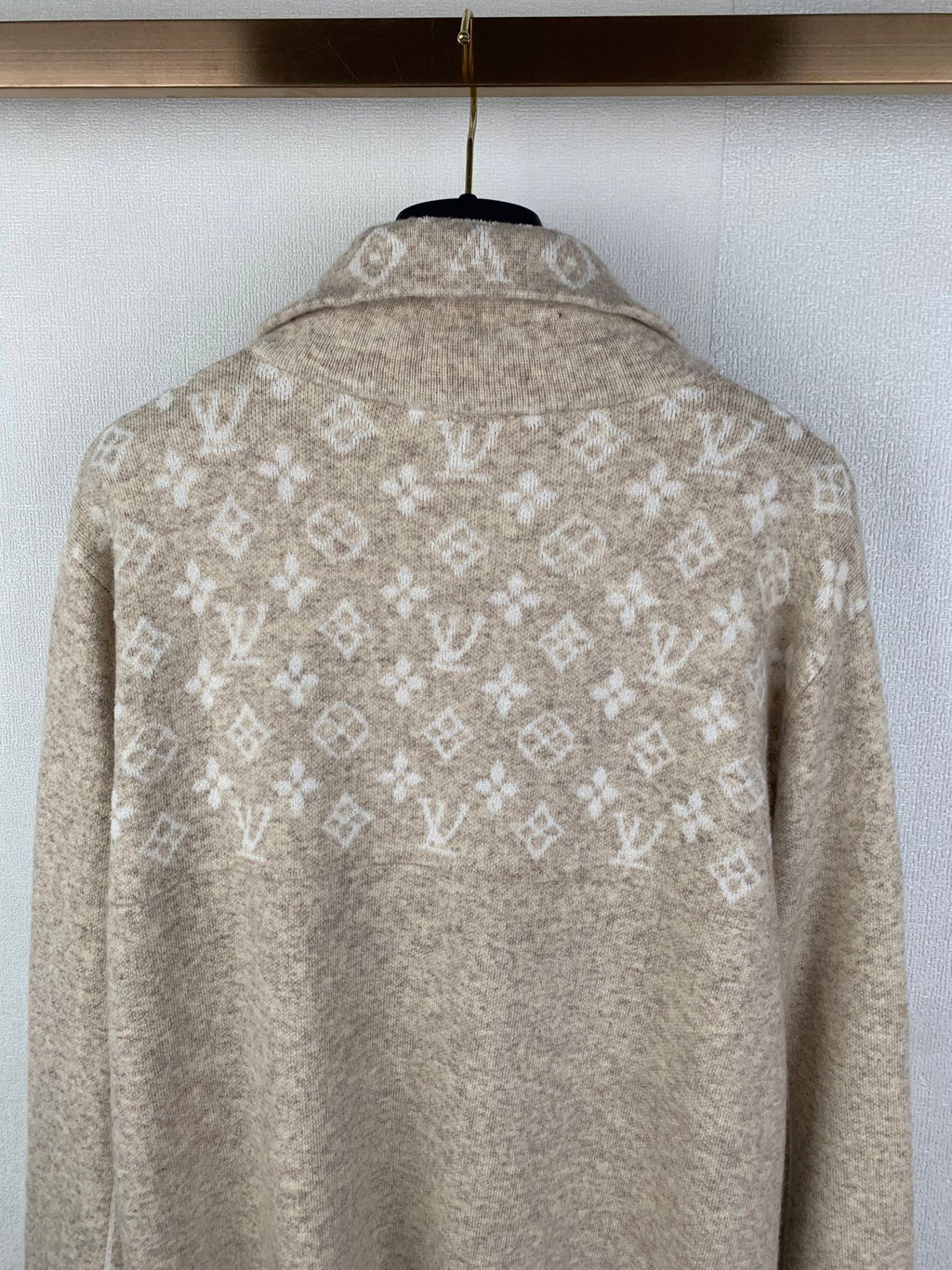 Back detail of light beige zip sweater with allover monogram motifs