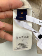 Clothing care label on beige knit sweater, size M, Italy, cold machine wash