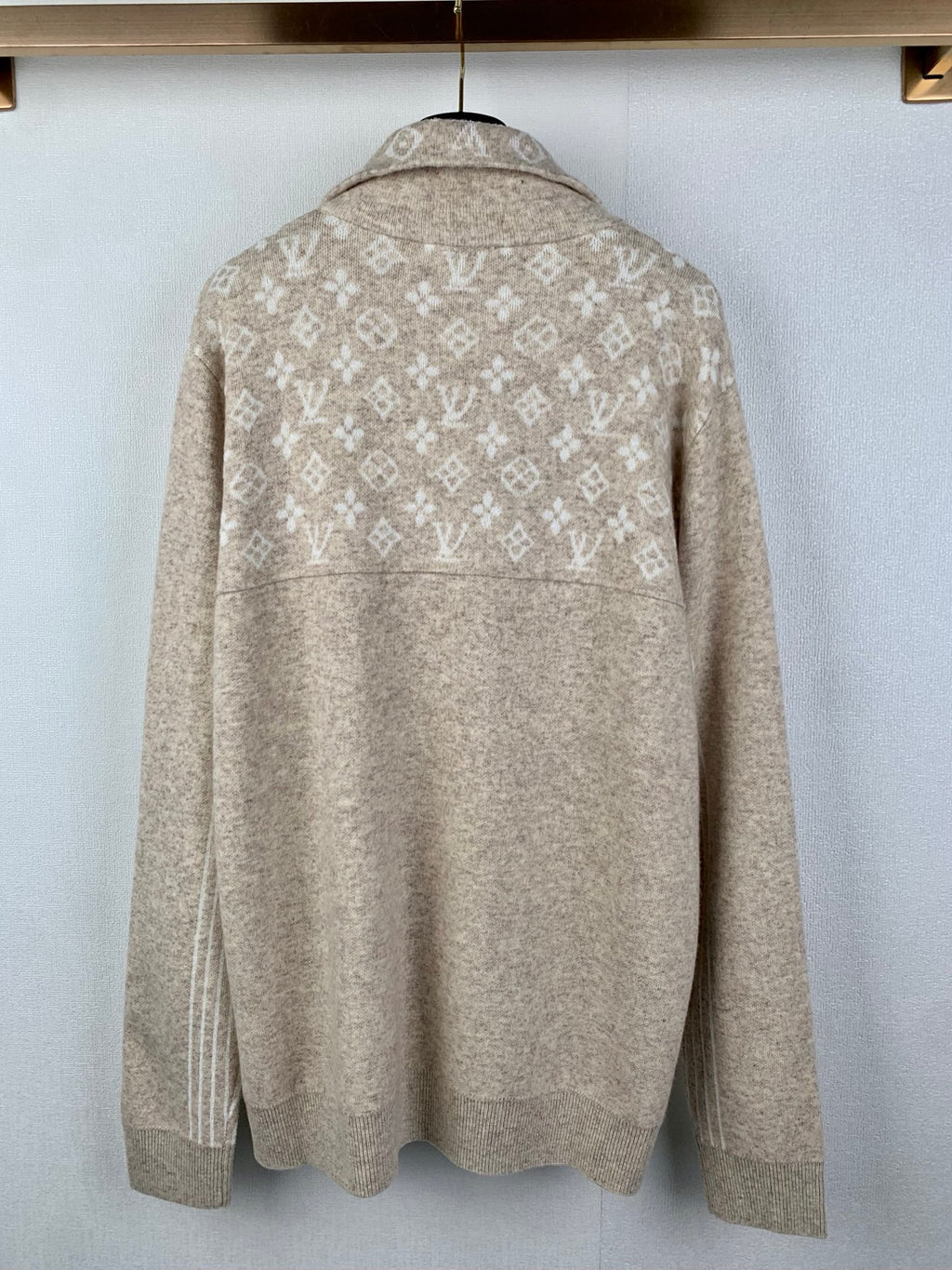 Back view of long-sleeve zip sweater in light beige with repeating monogram pattern
