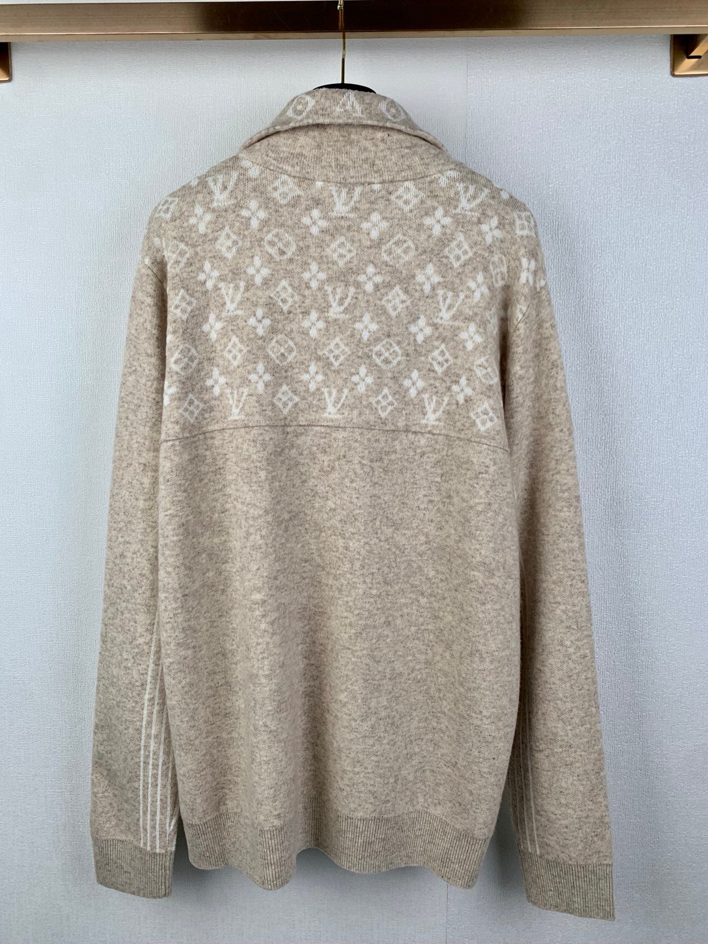 Back view of long-sleeve zip sweater in light beige with repeating monogram pattern