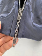 Dark blue hoodie close-up with metal zipper teeth and ribbed cuffs