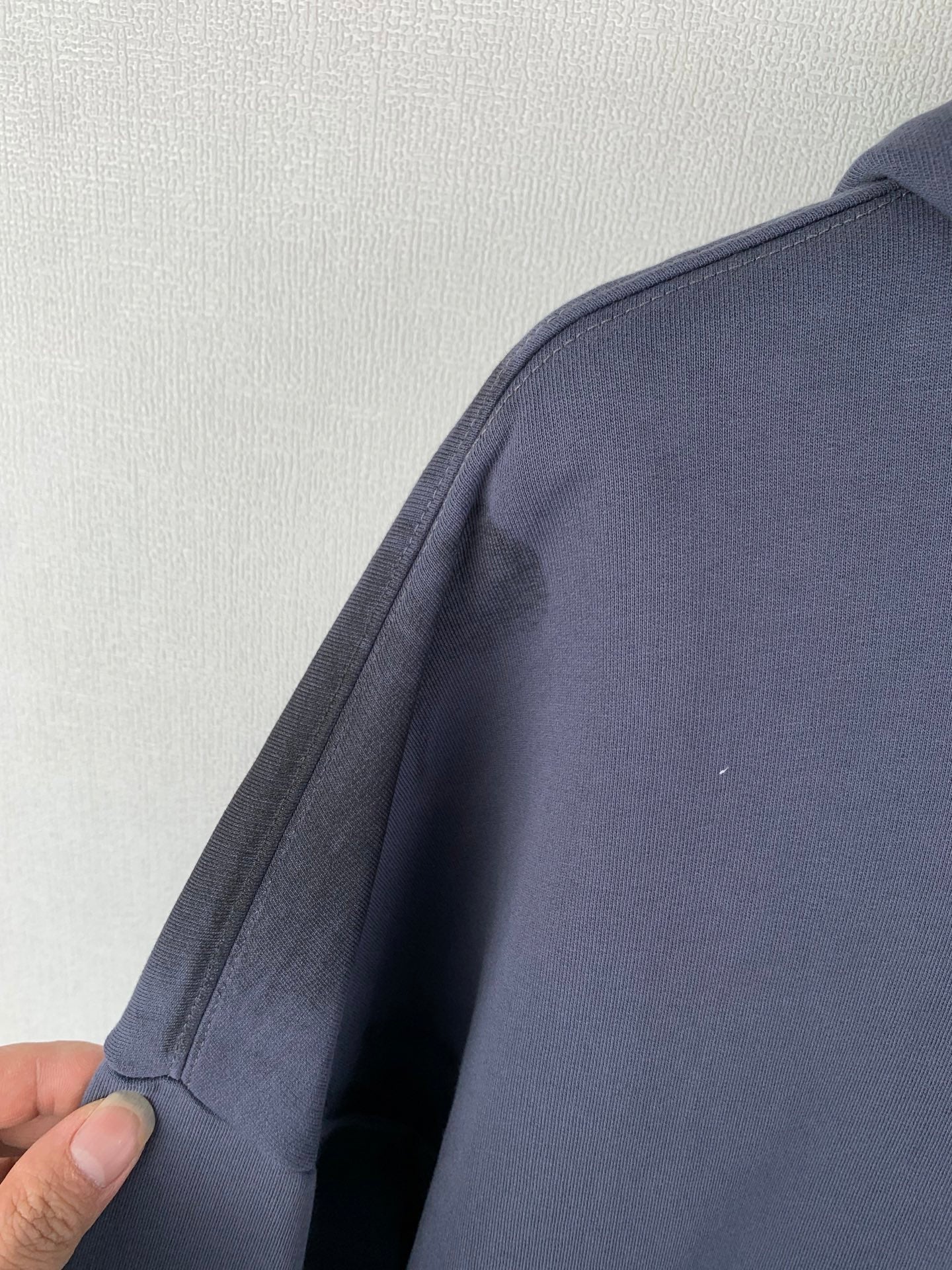 Dark blue zip-up hoodie sleeve and shoulder seam detail