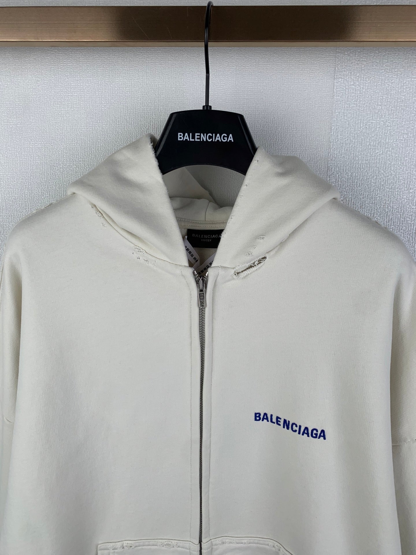 Cream zip-up hoodie with hood and blue BALENCIAGA logo on left chest