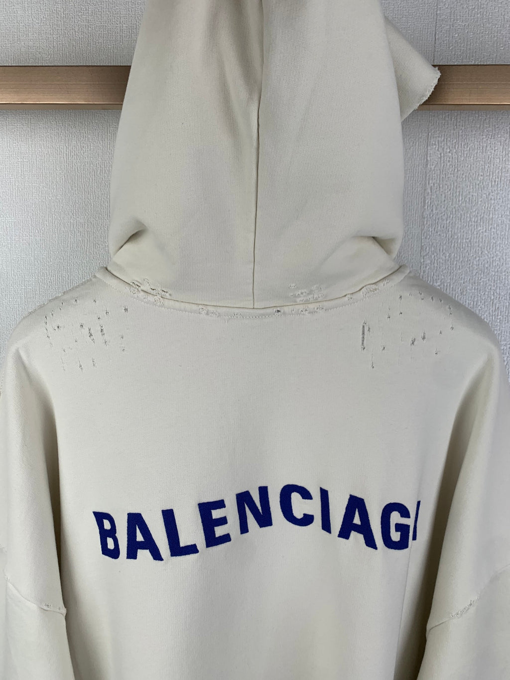 Cream hoodie back hood area with blue BALENCIAG lettering