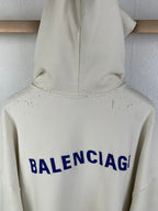 Cream hoodie back hood area with blue BALENCIAG lettering