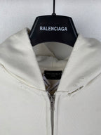 Cream zip-up hoodie with hood and inner label; silver zipper