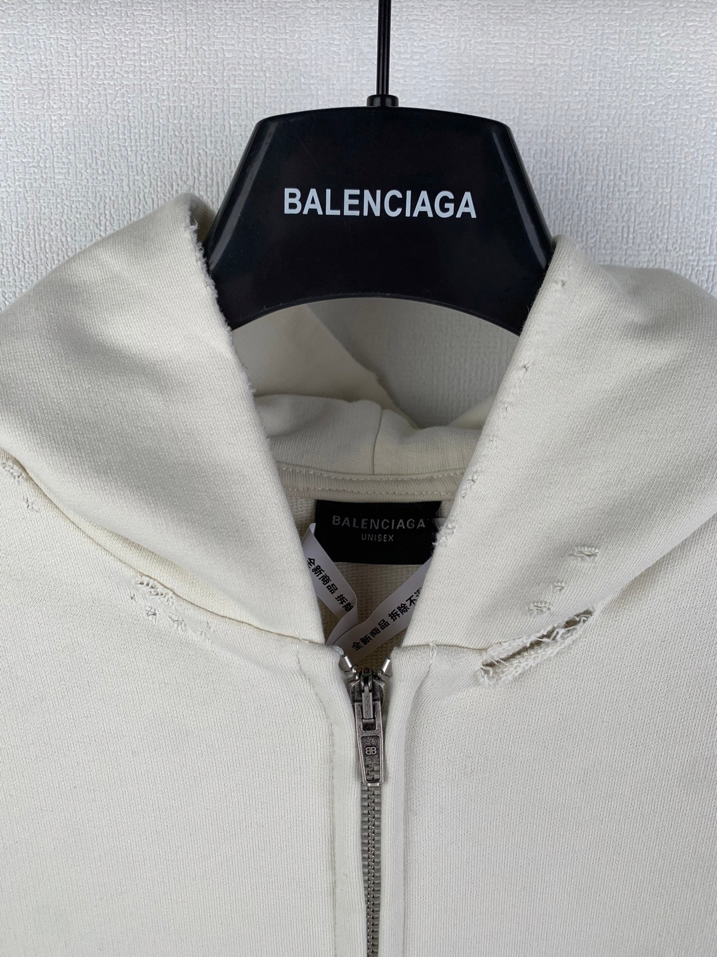 Cream zip-up hoodie with hood and inner label; silver zipper