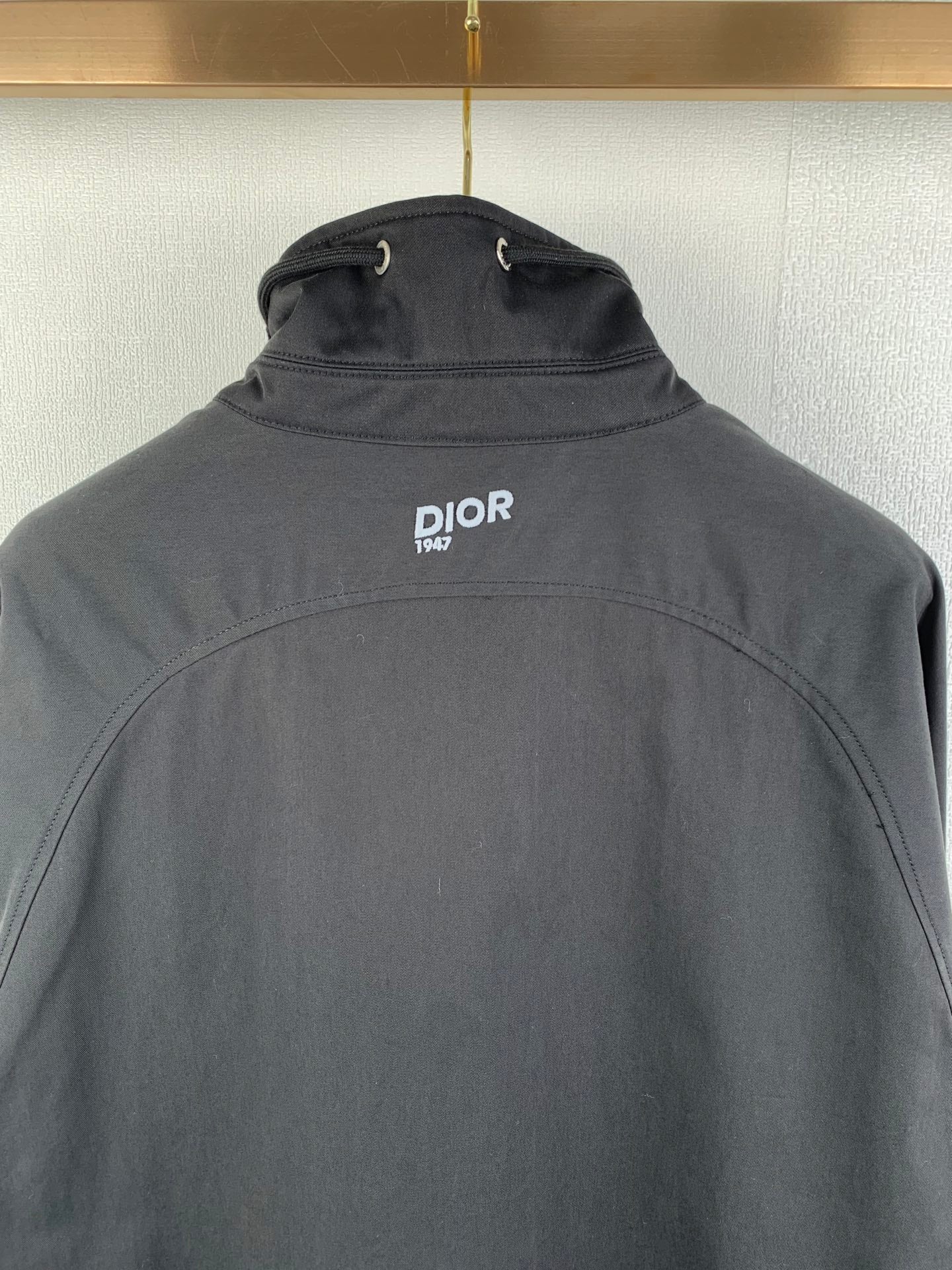 Dark gray Dior jacket back with stand collar and small DIOR 1947 logo