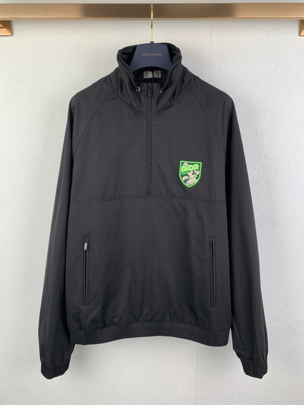 Black Dior zip-up jacket with stand collar, two front pockets, and logo patch